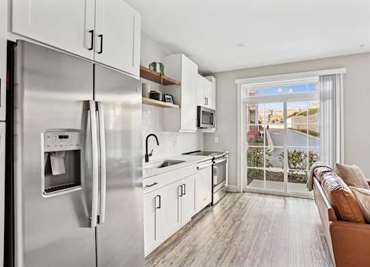 A modern kitchen with stainless steel appliances and white cabinets.