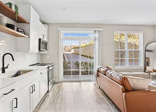 A modern kitchen with a couch and a view of the outside.