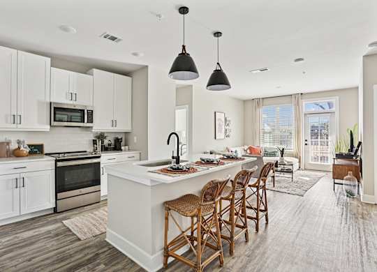 A modern kitchen with a large island and wooden chairs.