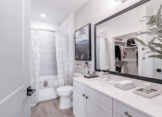 Full bathroom with a bathtub with tile backdrop at Novel Cary