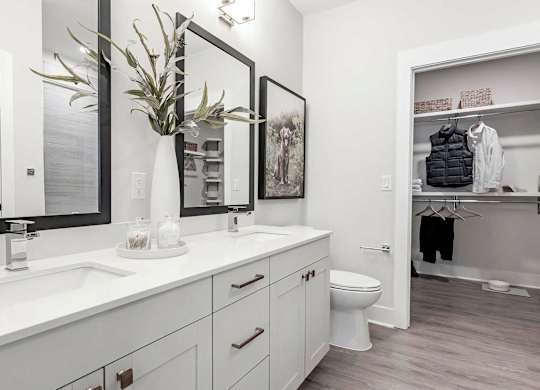 Luxurious bathroom with double vanity and spacious walk-in closet at Novel Cary