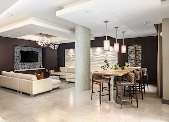 Resident Club Room Featuring TV, Lounge Seating, and Modern Pendant Lighting