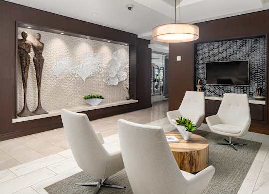 Apartment Lobby with Contemporary Seating, Sculptural Wall Art, and Mounted TV