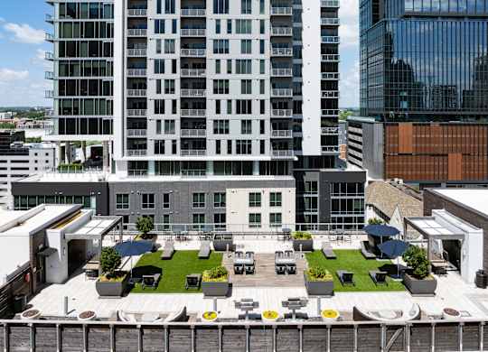 A modern building with a rooftop garden and seating area.