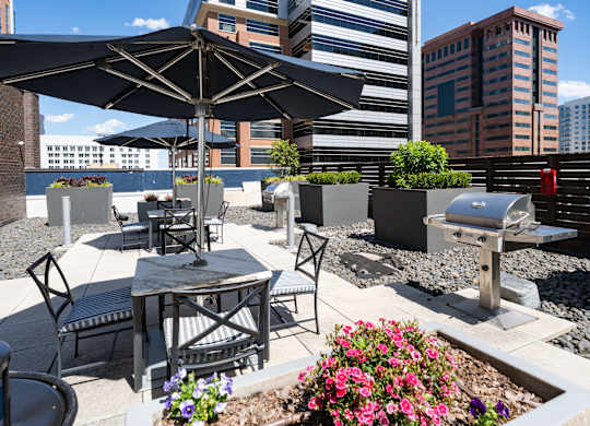 A patio with a table, chairs, and umbrella.