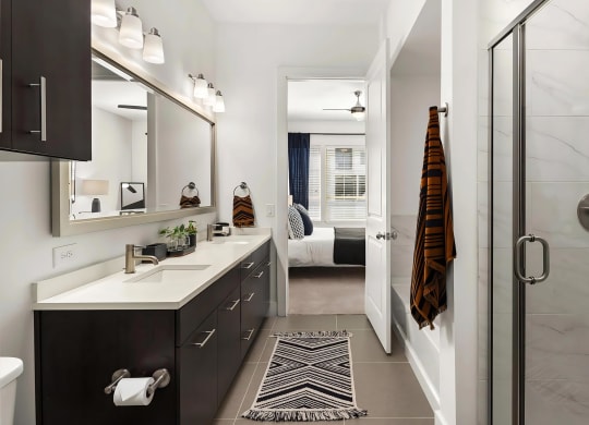 Ensuite Bathroom Featuring Dual Vanities and Glass Walk-In Shower