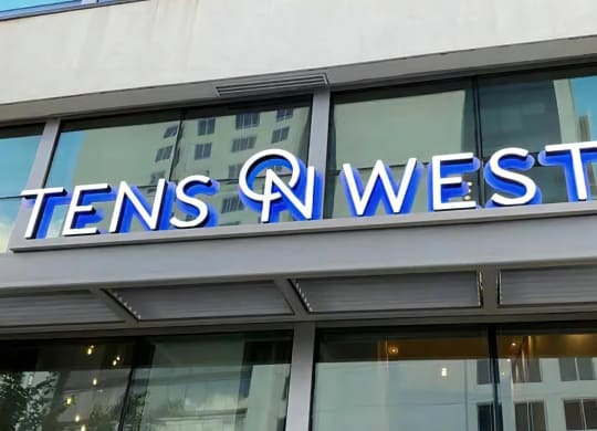 Close-Up of Tens on West Apartment Name on Glass Building Facade