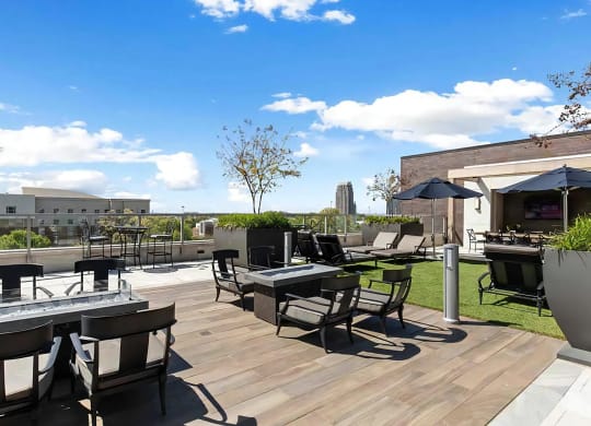 Rooftop Lounge Area With Fire Pits, Seating, and Shade Umbrellas