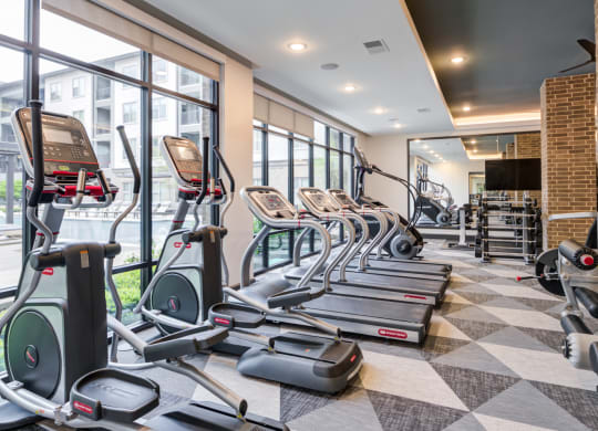 Spacious Fitness Center With Cardio Machines and Pool Views