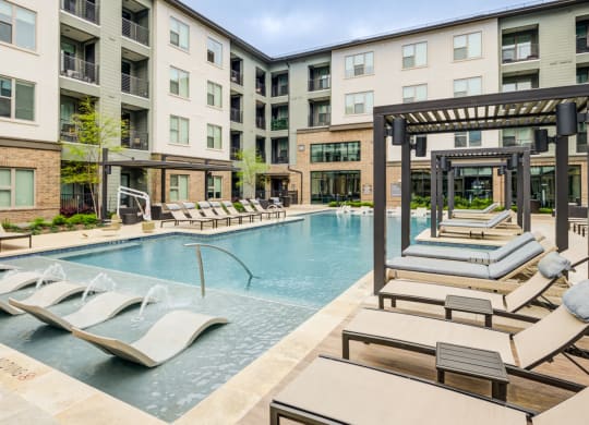 Resort-Style Pool With In-Water Loungers and Private Cabanas