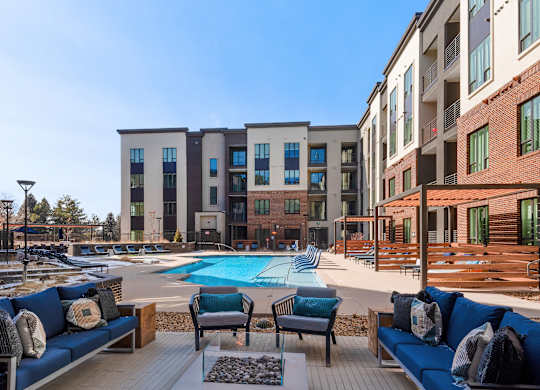 Spacious Poolside Lounge with Cushioned Seating and Fire Feature