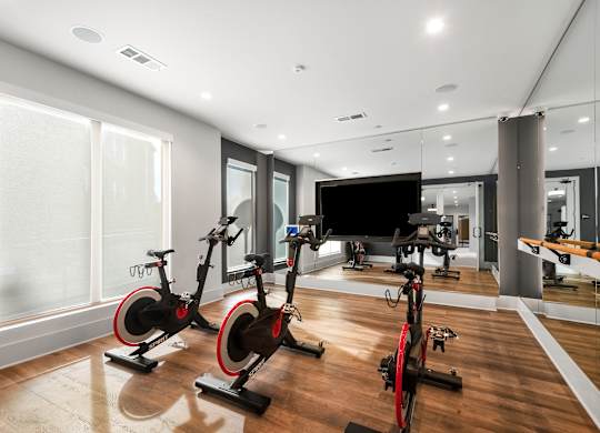 Fitness Studio with Spin Bikes, Wall Mirror, and Mounted TV