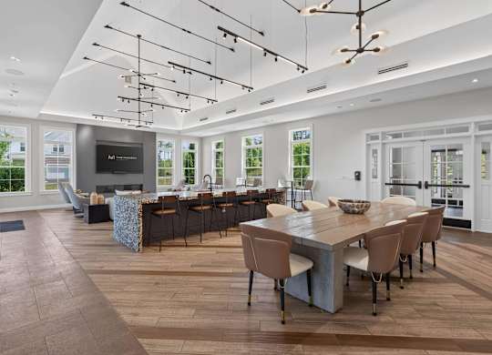 Clubhouse with a catering kitchen, bar seating, dining space, and lounge at Madison at Marshfield.
