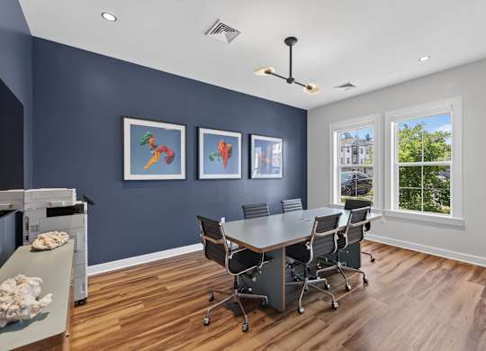 Conference room with a long table, rolling chairs, and large windows at Madison at Marshfield.