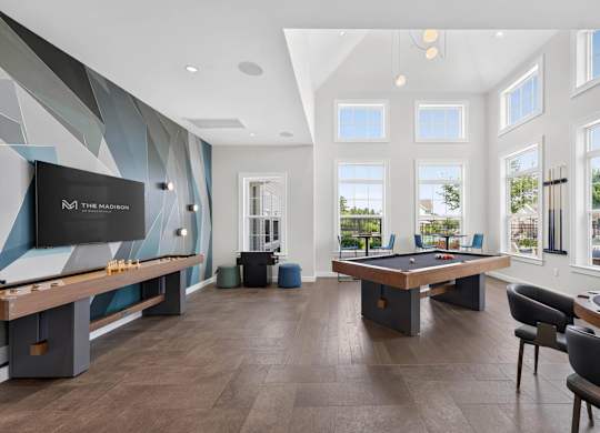 Game room with pool and shuffleboard tables at The Madison at Marshfield.