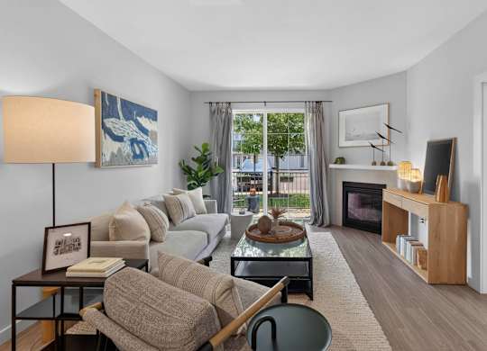 Apartment living room with a gas fireplace and patio door at Madison at Marshfield.