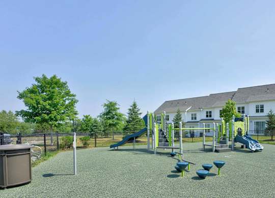 Outdoor playground with slides and climbing equipment at The Madison at Marshfield.