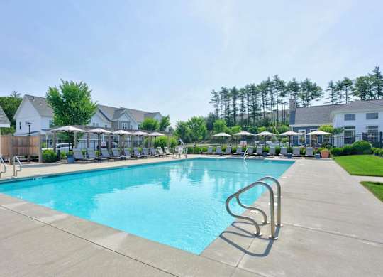 Saltwater pool with lounge seating and apartment buildings at The Madison at Marshfield.