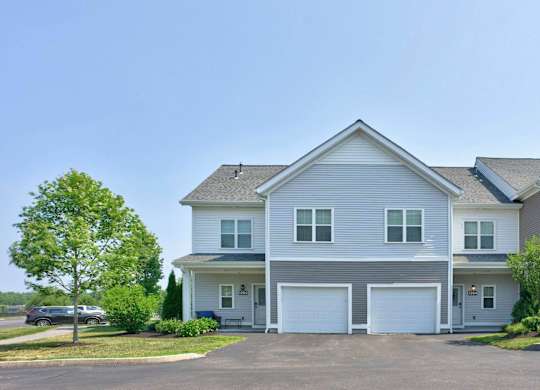 Gray townhomes with individual entrances and attached garages at The Madison at Marshfield.
