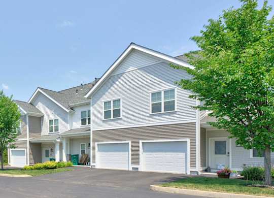 Gray townhomes with attached garages and individual entrances at Madison at Marshfield.