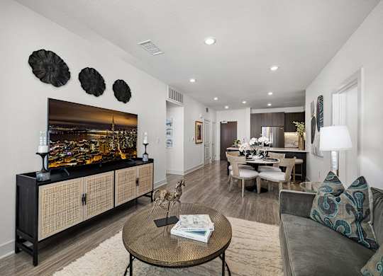 Stylish living space with soft textures, a sleek media console, and wide windows for abundant light