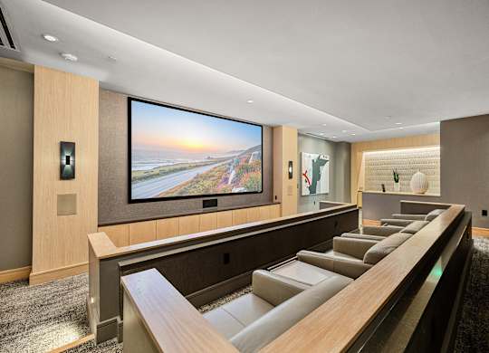 Private theater room with oversized screen, plush leather seating, and intimate lighting for movie nights