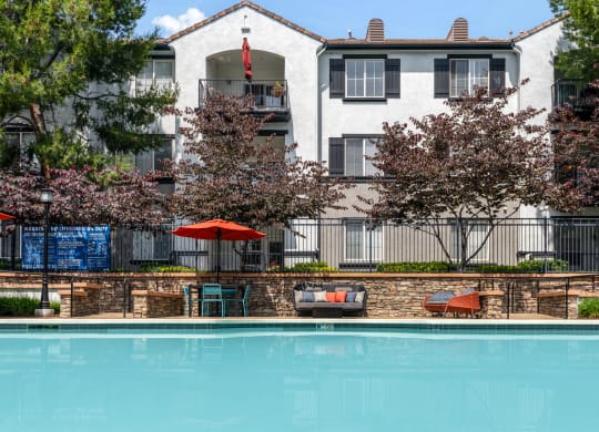 Pet-Friendly Luxury Apartments In Rancho Cucamonga, CA - Villas At The Gardens - Resort-Style Pool Deck With Spa, Umbrella Tables, Chairs, And Lounge Seats.