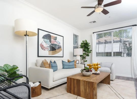 Living Room with Ceiling Fan and Multiple Windows
