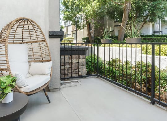 Peaceful Apartment Patio with Wicker Furniture and Greenery