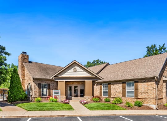 a brick house with a porch and a lawn
