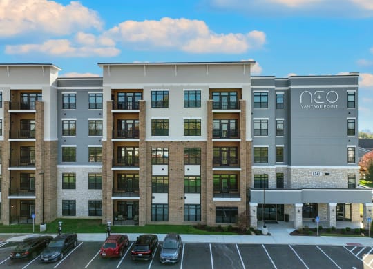 a large apartment building with cars parked in a parking lot