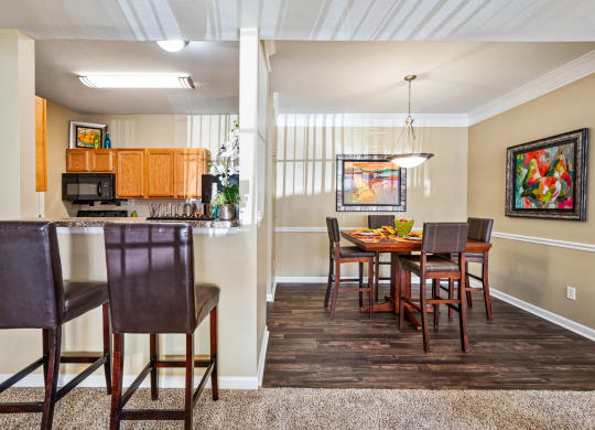 a dining room with a table and chairs next to a kitchen with a counter top