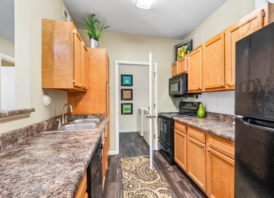 a kitchen with granite counter tops and black appliances