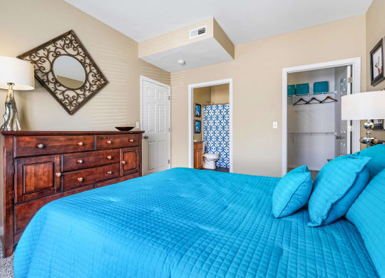 a bedroom with a blue bed and a dresser