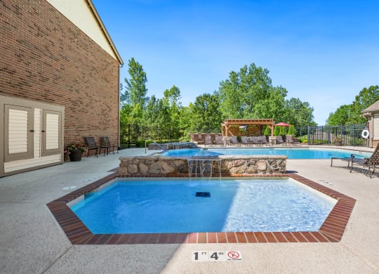 our resort style swimming pool is next to our house with a spa and a patio