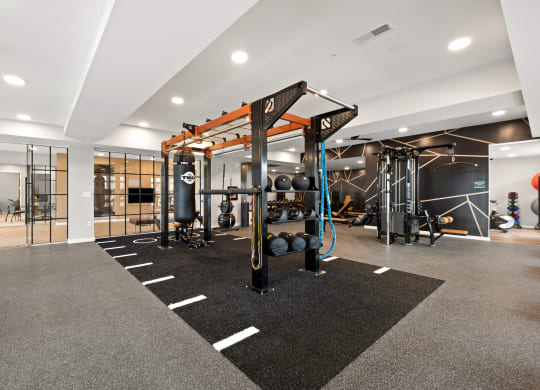 a gym with weights and other exercise equipment in a building with glass doors