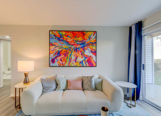 a living room with a couch and a painting on the wall