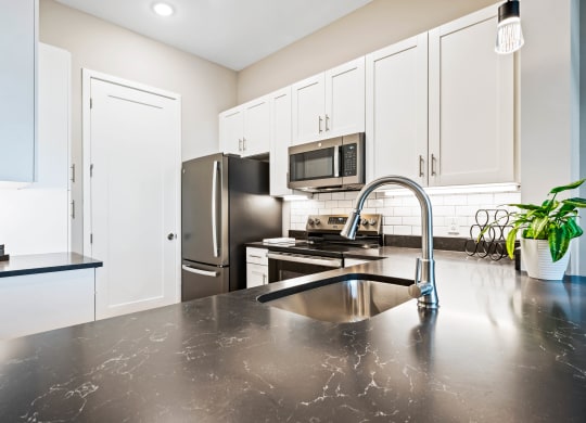 a modern kitchen with stainless steel appliances and black counter tops