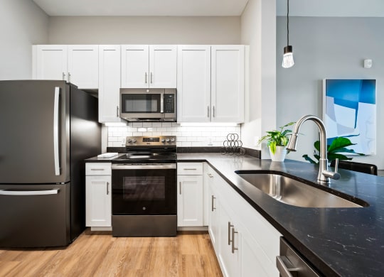 a kitchen with stainless steel appliances and black counter tops