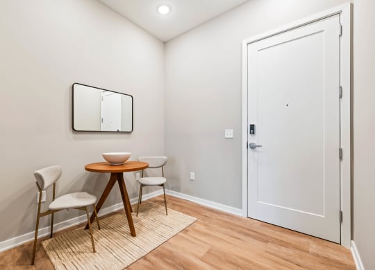 a small dining room with two chairs and a table and a door