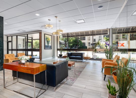 the lobby of a hotel with chairs and a table