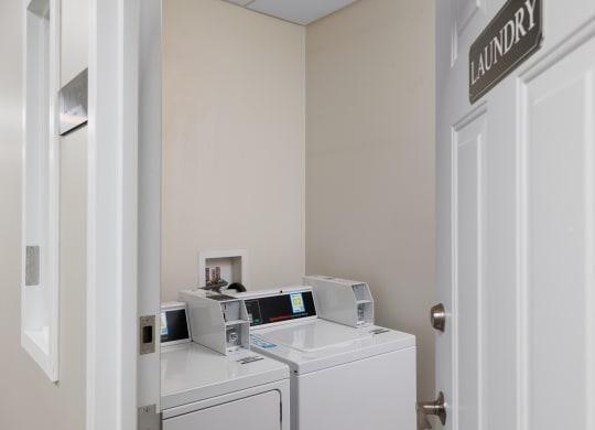 a laundry room with two washers and two washing machines