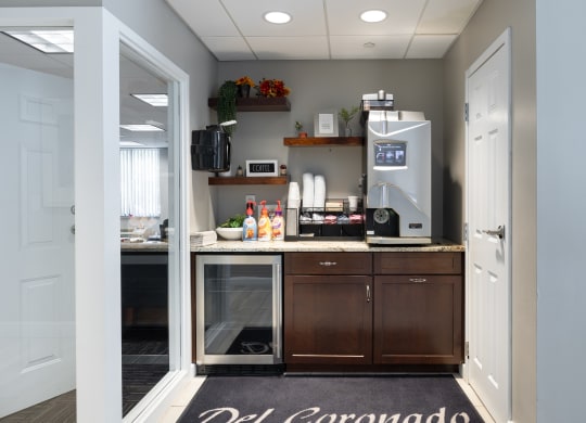 a kitchen with a coffee maker and a counter with a refrigerator