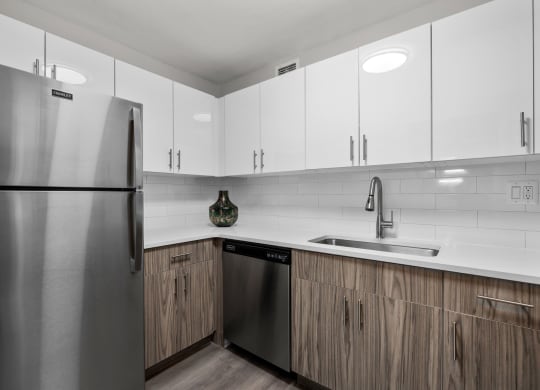 a kitchen with white cabinets and a stainless steel dishwasher