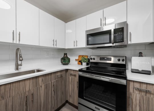 a kitchen with white cabinets and black appliances