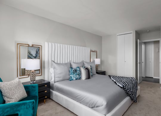 a bedroom with a bed and a chair in a room