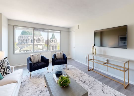 a living room with a large window and a tv on the wall