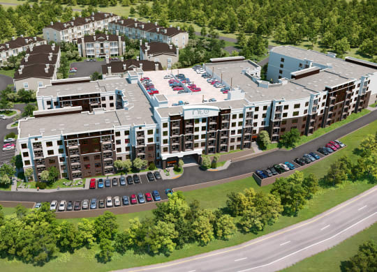 an aerial view of a large apartment complex with cars parked in front of it