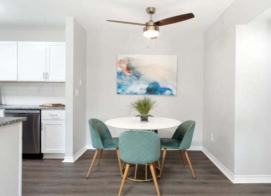 a dining room with a table and chairs and a ceiling fan