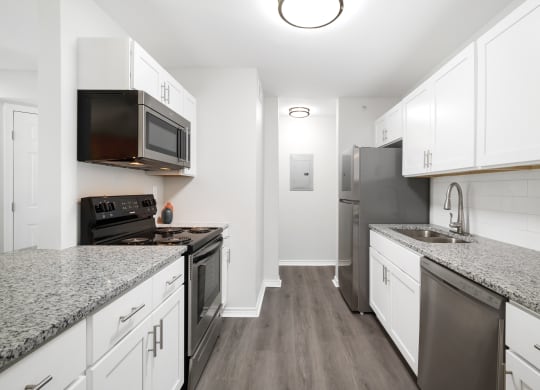 a kitchen with white cabinets and stainless steel appliances and granite counter tops
